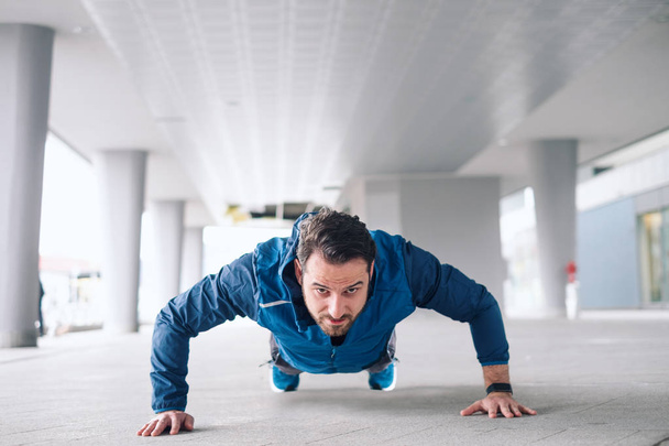 Urban sportsman doing push-ups reps exercise - Valokuva, kuva