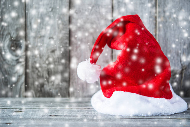Weihnachtsmann-Hut auf grauem Holzhintergrund - Foto, Bild
