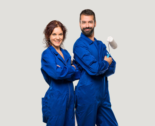 Painters keeping the arms crossed in lateral position while smiling on isolated grey background - Foto, Imagem