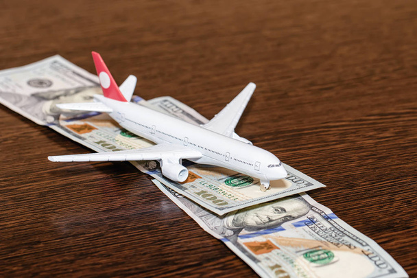 Toy airplane on the runway of hundred dollar bills - 写真・画像