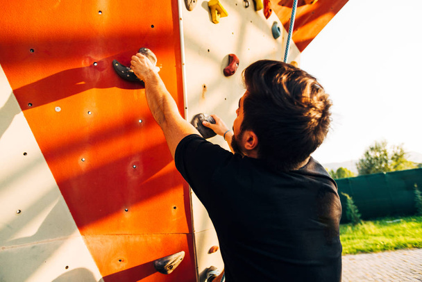 Jovem escalada parede rock um esporte extremo
 - Foto, Imagem