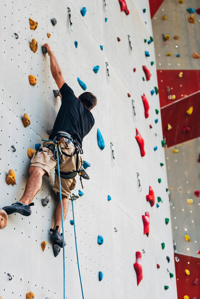 Młody człowiek, sportowy jest bouldering w Hala wspinaczkowa - Zdjęcie, obraz