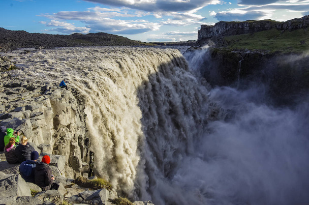 Tourist on the edg of Detifoss waterfall. One of the best attraction in Iceland. Dettifoss is the most powerful waterfall on Iceland and in the whole Europe - 写真・画像
