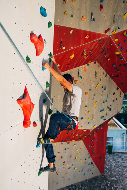 Joven practicando bouldering en gimnasio de escalada al aire libre
 - Foto, Imagen