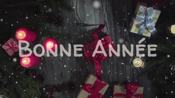 Animatie Bonne Annee - gelukkig Nieuwjaar in Frans, witte letters, rode kaarsen en cadeau - Video