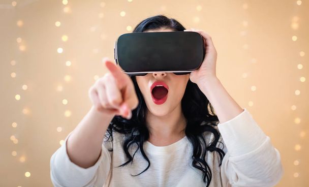 Young woman using a virtual reality headset - 写真・画像