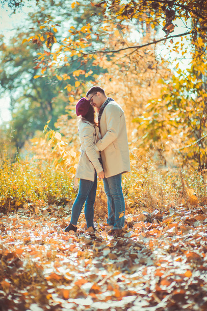 Loving couple is outdoors, cuddling and kissing in the park in autumn - Foto, Bild
