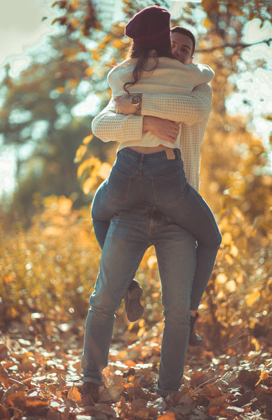 Χαριτωμένο ζευγάρι είναι στο πάρκο το φθινόπωρο, απολαμβάνοντας την ημέρα και ψάχνει ευτυχής μαζί - Φωτογραφία, εικόνα