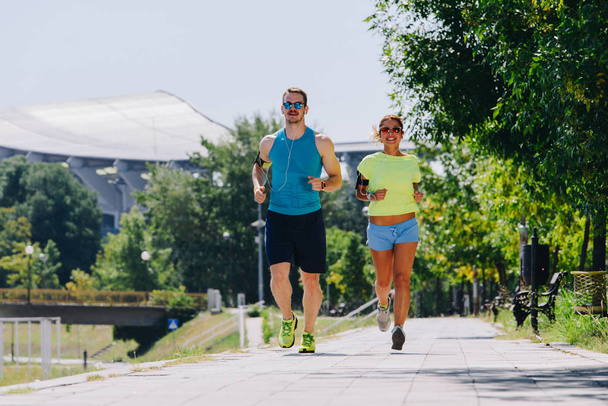 Mladý sportovní pár dělá běh cvičení na riverside - Fotografie, Obrázek