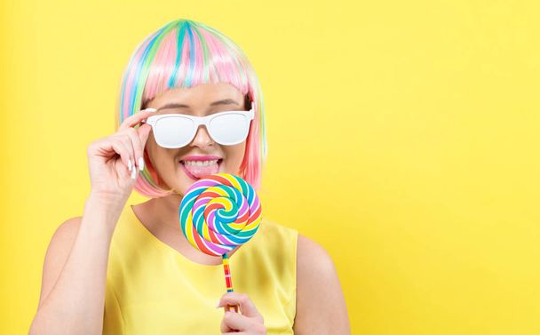 Woman in a colorful wig with a lollipop - Фото, зображення