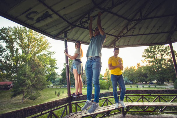 Jóvenes, gente descuidada de pie y trepando sobre tablas de madera, divirtiéndose juntos
 - Foto, imagen