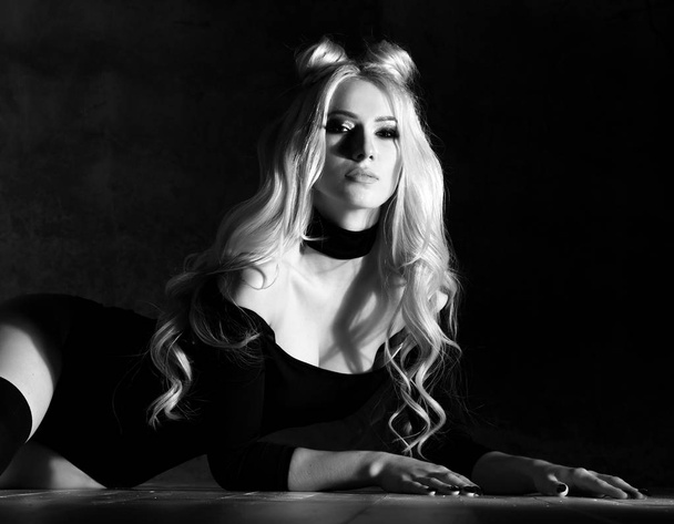 Young sexy blonde fashion woman sitting on floor in black body cloth and choker  - Фото, зображення
