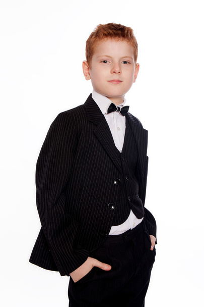 Вoy with red hair in a black suit with bow tie - Fotografie, Obrázek