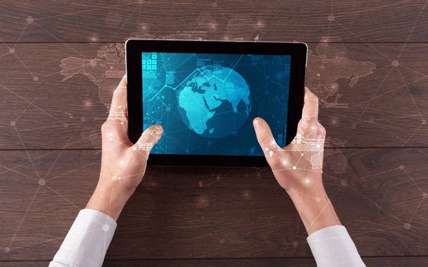 Hand holding tablet with global reports and stock market change concept - Foto, afbeelding