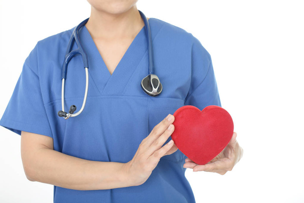 Female doctor holding red heart love symbol - Valokuva, kuva