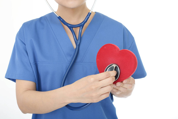 Female doctor holding red heart love symbol - 写真・画像