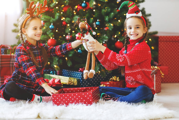 happy children girls with christmas gifts near christmas tree in mornin - Foto, imagen