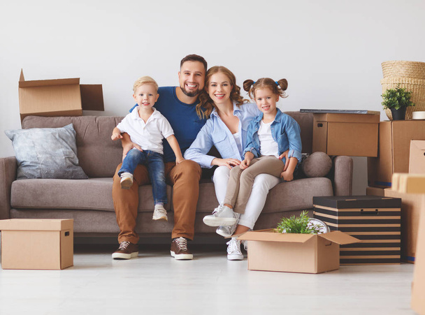 ευτυχισμένη οικογένεια μητέρα ο πατέρας και τα παιδιά μετακινούνται σε ένα νέο διαμέρισμα και απλήρωτος boxe - Φωτογραφία, εικόνα