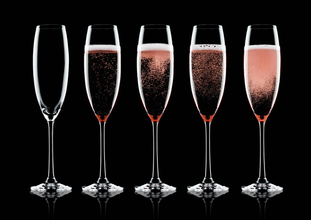 Rose pink champagne glasses with bubbles on black background with reflection - Foto, immagini