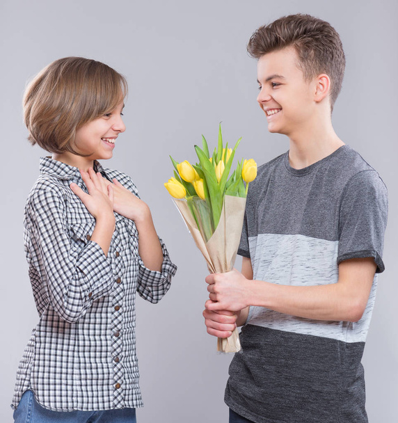 Teen boy and girl with flowers - Valokuva, kuva