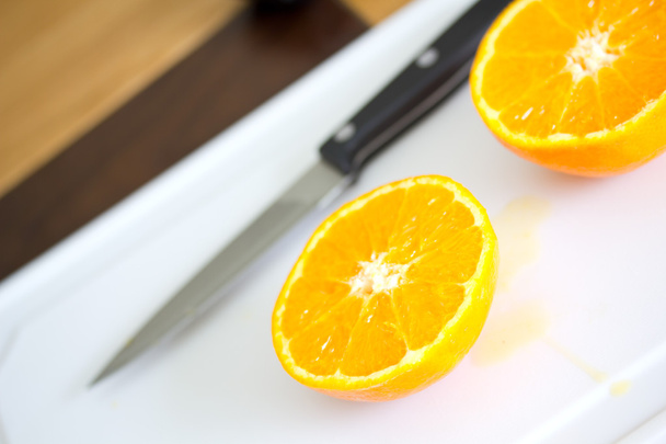 Naranja en rodajas con cuchillo
 - Foto, imagen