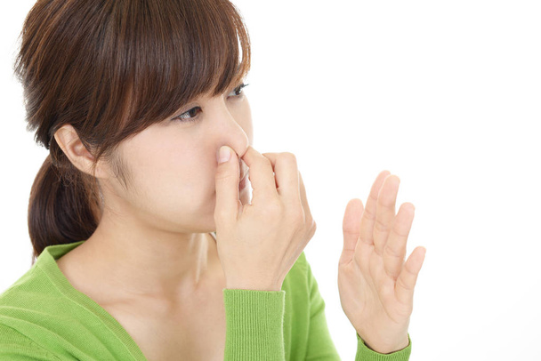 vrouw wringt haar neus - Foto, afbeelding