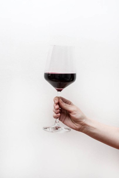 hand with glass of red wine - Foto, afbeelding