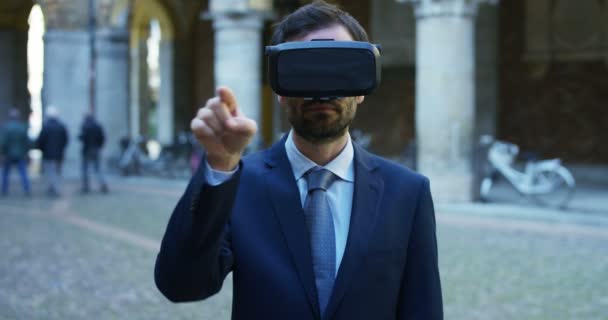 A businessman in a suit uses augmented reality in the city among the people. Concept: immersive technology, augmented reality and futuristic business. - Footage, Video