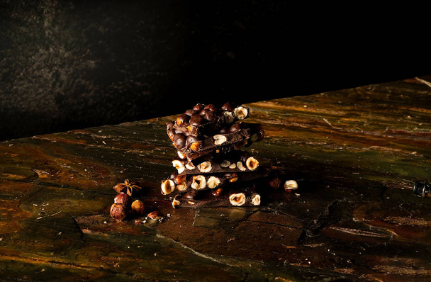Κομμάτια σοκολάτας με αμύγδαλα σε σκούρο φόντο. Χώρο αντίγραφο, κοντινό πλάνο  - Φωτογραφία, εικόνα