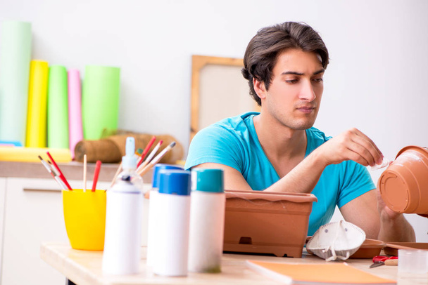 Молодий чоловік прикрашає кераміку в класі
 - Фото, зображення