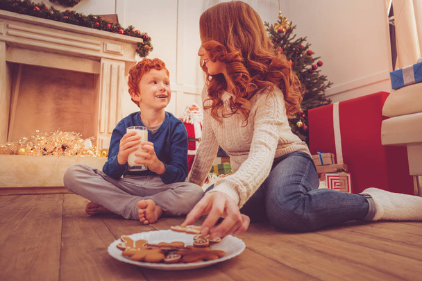Charming mother and son eating cookies on Christmas Eve - Valokuva, kuva