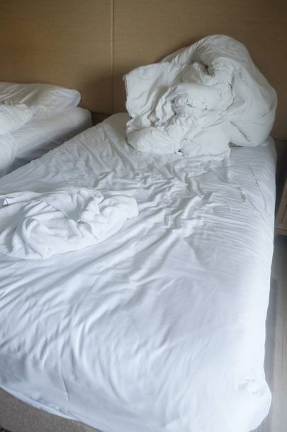 Couverture salissante et oreiller blanc dans la chambre à coucher après s'être réveillé le matin après avoir dormi dans une longue nuit
 - Photo, image