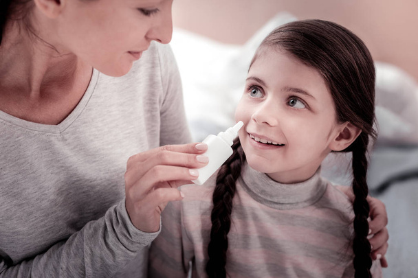 Nahaufnahme eines entzückten Kindes mit Nasentropfen - Foto, Bild
