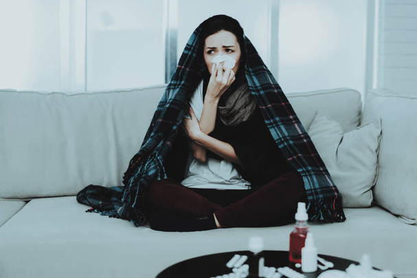 Upset Woman with Cold on Sofa in Scarf at Home. Sick Young Woman. White Sofa in Room. Unhappy Woman. Disease Concept. Healthcare and Healthy Lifestyle Concept. Unhappy Girl. Modern Medicine. - Fotó, kép