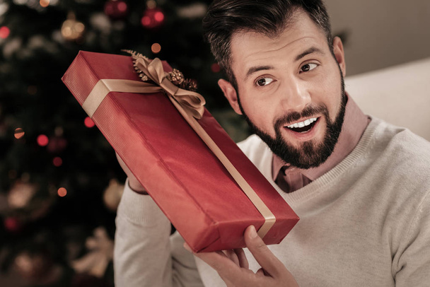 Pleased brunette male guessing his present - Foto, Bild