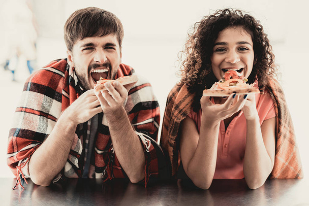 Young Couple in Checkered Plaids Eating Pizza. Street Food Concept. Food in Town. Selling Snacks. Girfriend and Boyfriend. Summer Day. Square in European City. Smiling People in Blanket. - Fotó, kép