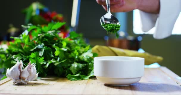 Slow motion of chef adding parsley in bowl - 映像、動画