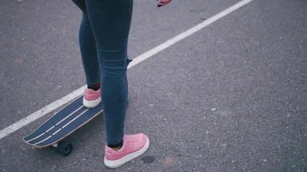 Nuori kaunis kaunis vaalea hipster nainen vaaleanpunainen tuulitulppa hauskaa ratsastus rullalauta longboard alamäkeen kauniilla tiellä hidastettuna
 - Materiaali, video