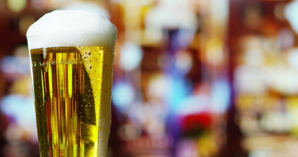 video stromende bier in pint glas met schuim  - Video