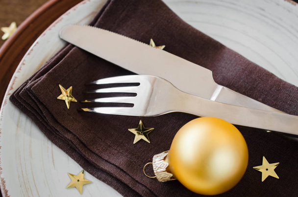 Simple Christmas table place setting on wooden background in vintage or rustic style. Festive table set for christmas or new year dinner. - Photo, Image