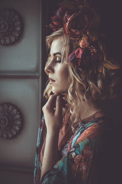 Beautiful woman in a dress of floral colors with wreath of flowe - Fotografie, Obrázek