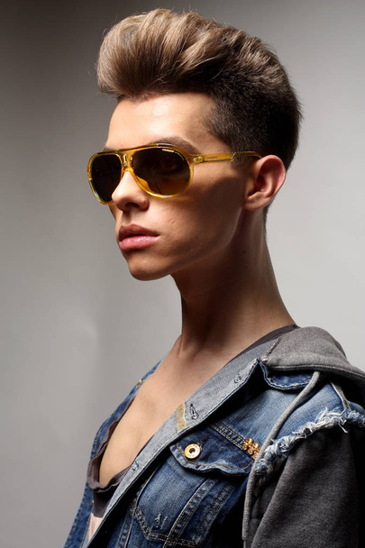 The beautiful young man in sunglasses on a white background. Fas - 写真・画像