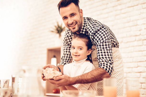 Cook Food at Home. Happy Family. Father's Day. Girl and Man Cooking Smiling Man and Child at Table. Spend Time Together. Food on Table. Egg in Bowl. Pour Flour. Cook Dough. Dough in Hands. - Fotoğraf, Görsel