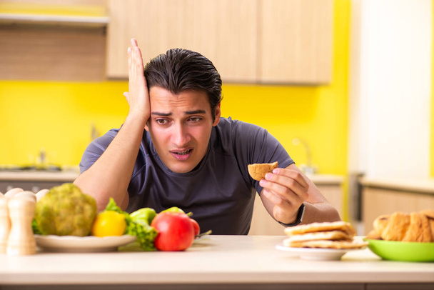 Man having hard choice between healthy and unhealthy food - Φωτογραφία, εικόνα