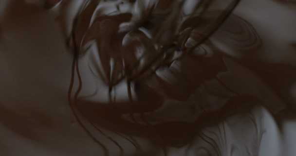Super SlowMotion van warme chocoladesaus zweepslagen met een roestvrijstalen garde op de keuken van een restaurant in 4k (macro close-up) - Video