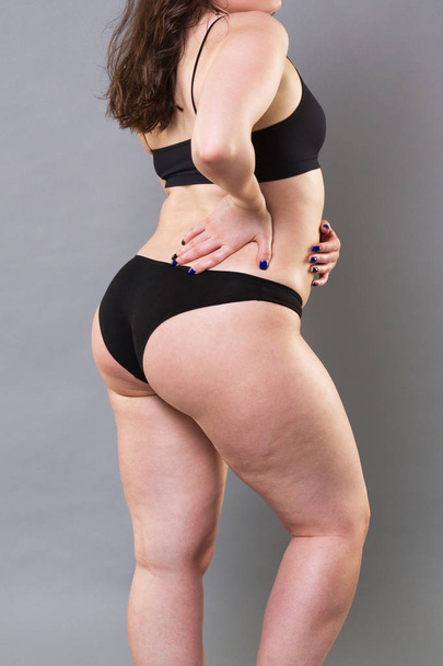 Woman in black underwear on gray background, cellulite on female body, studio shot - Photo, image