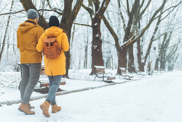 Pärchen spazieren durch den verschneiten Stadtpark und unterhalten sich. romantisches Date im Winter. Weihnachten naht - Foto, Bild