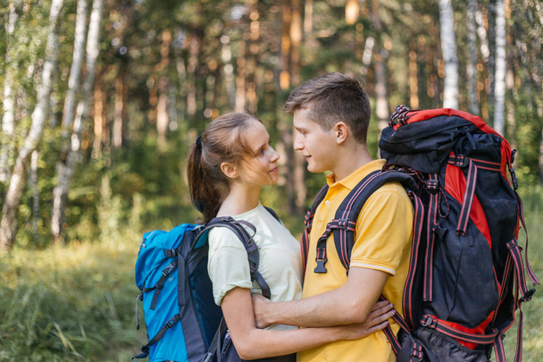 couple of tourists with backpacks hiking in a forest - Φωτογραφία, εικόνα