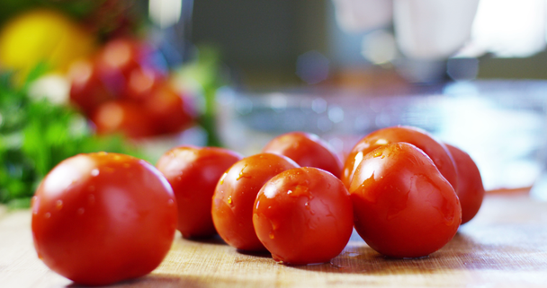 αργή κίνηση βίντεο των χεριών κρατώντας υγρές πλυμένες κόκκινες ντομάτες  - Πλάνα, βίντεο