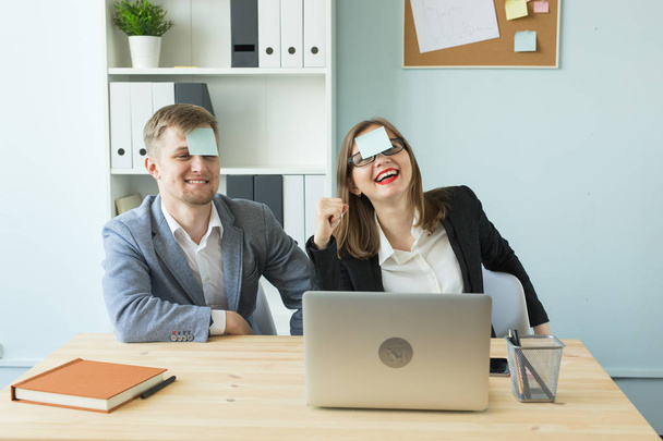 Concept d'entreprise, de pause et de personnes - Homme et femme joyeux jouant à des jeux au bureau tout en travaillant
 - Photo, image